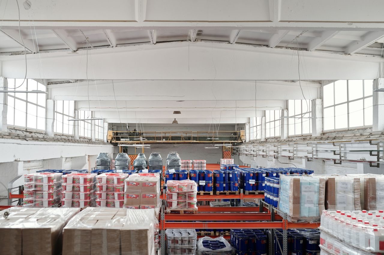 Free Spacious warehouse interior featuring organized shelves with various stacked pallets. Stock Photo